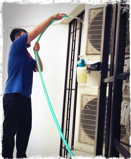 technician cleaning aircon outdoor unit